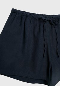 Námořnické modré kraťasy vyrobené z měkké tkaniny, s elastickým pasem a nastavitelnou šňůrkou, v uvolněném střihu.