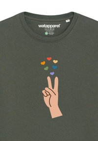 T-shirt en coton vert foncé avec une main faisant un signe de paix, entourée de cœurs colorés en jaune, orange, vert, bleu, violet et lavande.