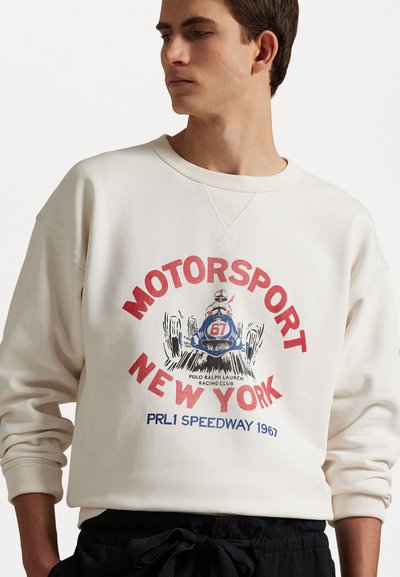 Sweatshirt in crème met een ronde halslijn, voorzien van een rood en blauwe grafische print van een racekart. Lange mouwen met ribgebreide manchetten.