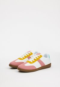 Zapatillas coloridas con paneles en rosa, blanco y amarillo, con un acabado texturizado, cordones blancos y un acento azul claro en el talón.