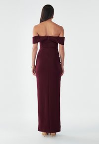 Burgundia õlast avatud kleit, millel on lõikekuju, tagumine lukuga sulgemine ja sile tekstuur, ulatub põrandani.