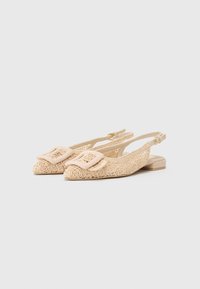 Bezs színű, virágmintás csipke dizájnú, slingback cipők, lapos sarkúak, négyzet alakú csattal és nyitott oldalakkal. Texturált szövetből és szintetikus anyagokból készültek.