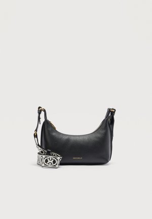 Melnas teksturētas ādas plecu soma ar zelta rāvējslēdzēju un noņemamu melnas un baltas rakstainas auduma siksnu.