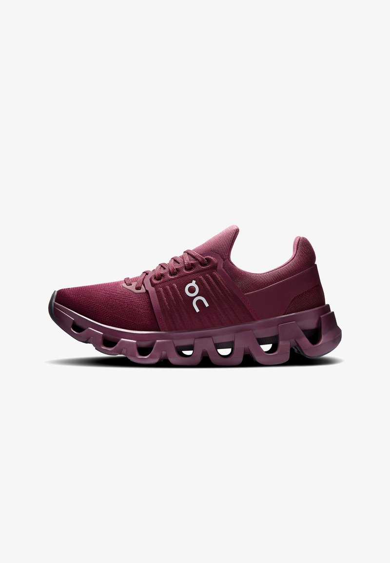 Chaussures de sport bordeaux avec tige en mesh respirant, semelle à découpe circulaire, et logo blanc sur le côté. Finition lisse et accents texturés.