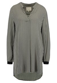 Blouse à manches longues en noir et crème avec un motif étoile géométrique. Design en V, ourlet incurvé et poignets côtelés noirs. Tissu léger.