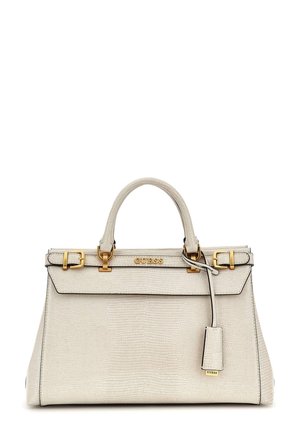 Sac à main en cuir texturé couleur crème avec boucles dorées et logo Guess, deux poignées et une étiquette suspendue sur fond blanc.