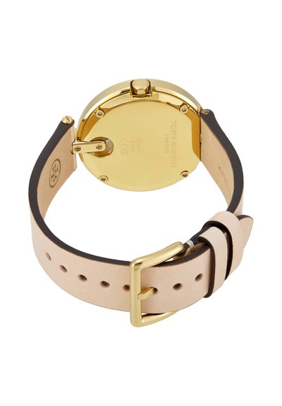 Goudkleurige horlogekast met beige leren band en gouden gesp, die de achterkant van een Tory Burch polshorloge toont.