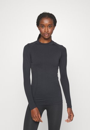Long-sleeve athletic top, dark navy color, ribbed texture on shoulders and sides, fitted design, crew neck, soft fabric.