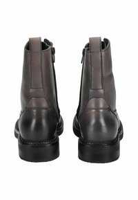 Bottes chevilles en cuir gris avec zippers et talon noir contrasté. Texture lisse, détails de couture et design à bout rond. Vue de dos.