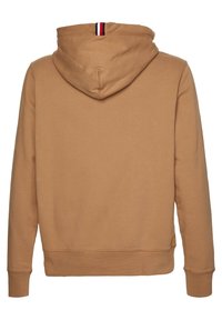 Brązowy hoodie z kapturem na sznurki, z prążkowanymi mankietami i dolnym brzegiem. Posiada trójkolorowy pasek akcentowy z tyłu szyi. Miękka tekstura materiału.