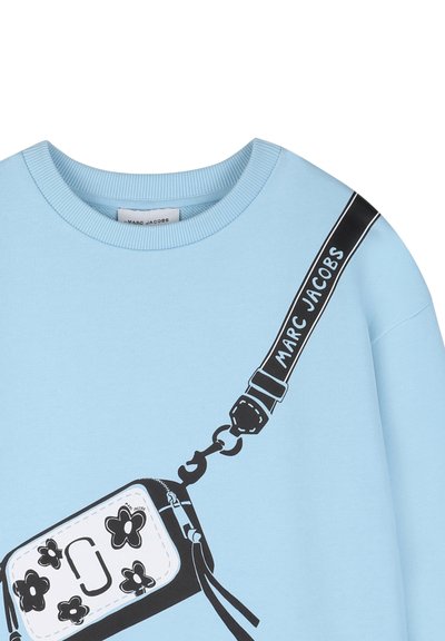 Sweat-shirt bleu clair Marc Jacobs avec un sac bandoulière imprimé en noir et blanc orné de motifs floraux et du texte « Marc Jacobs ».