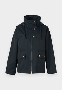 Veste imperméable bleu foncé avec col haut, garnitures dorées, deux poches avant et une fermeture éclair. Le matériau semble lisse et durable.