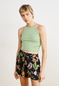 Világoszöld, bordázott, vékony pántos crop top, fekete, színes virágmintás sorttal, mely rugalmas derekú.