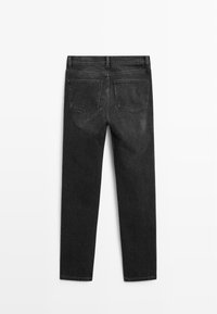 Vue de dos d'un jean en denim noir à jambe droite avec deux poches arrière et des passants de ceinture sur un fond uni.