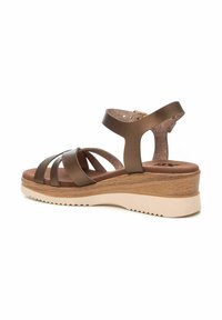 Sandalia cuña marrón con diseño de múltiples tiras cruzadas, plantilla acolchada, textura de madera en la cuña y suela de goma con patrón de zigzag.