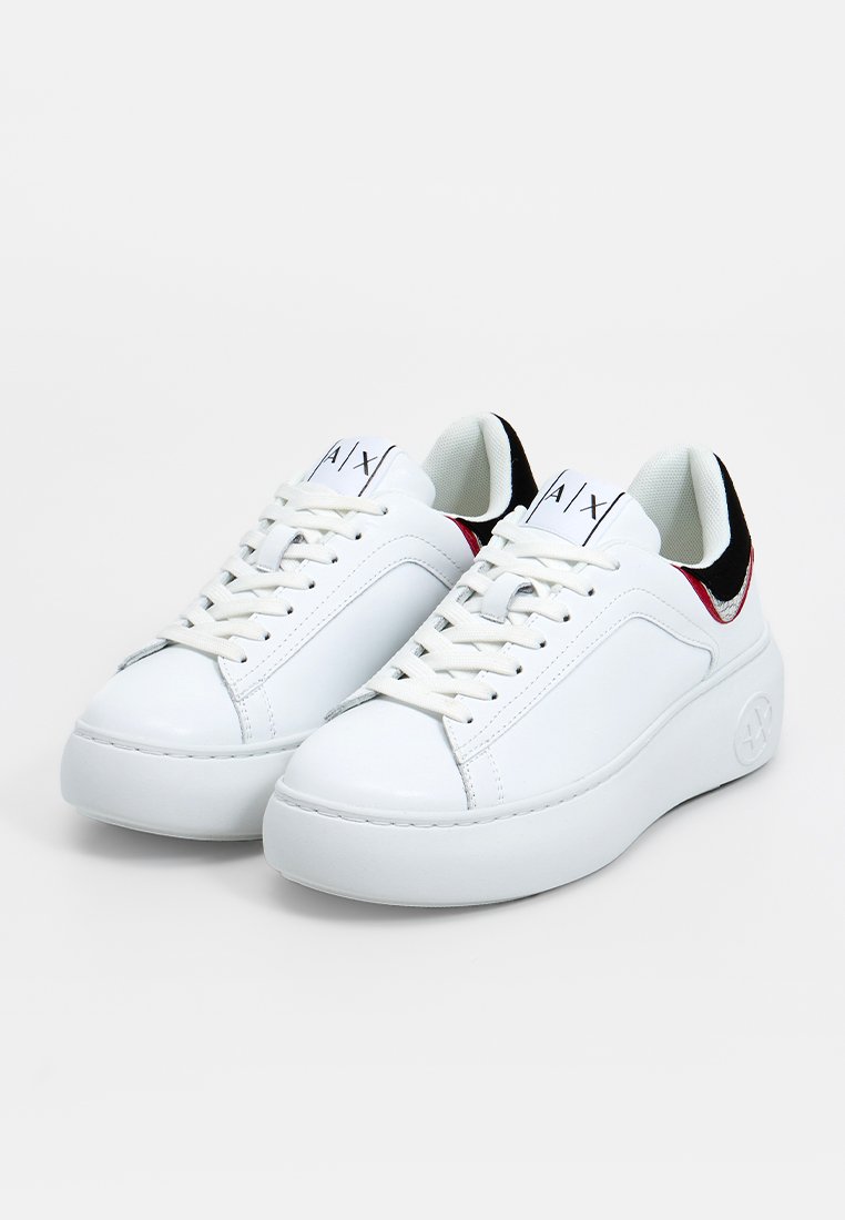 Białe sneakersy skórzane z okrągłym noskiem, platformą i kontrastującymi czarnymi i czerwonymi akcentami na pięcie. Zapięcie na sznurówki z logo.