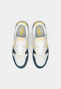 Lette sko i hvit, gul og marineblå. Teksturert mesh-overdel med semsket skinndetaljer. Snøring med polstret krage for komfort.