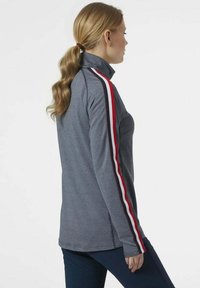 Pullover grigio con zip e colletto alto, caratterizzato da dettagli a strisce rosse e bianche lungo le maniche, realizzato in un morbido tessuto testurizzato.