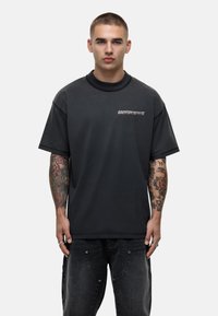 Zwarte oversized t-shirt, van katoen, met ronde hals, voorzien van de tekst "GOODFORNOTHING" op de linkerborst. Textuurstof en ruime pasvorm.