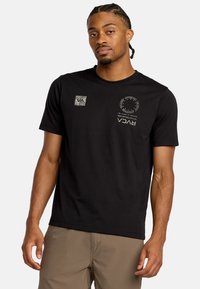 Maglietta nera in cotone con stampe del logo in argento e grigio. Maniche corte, colletto tondo e vestibilità regolare. Design semplice e minimalista.