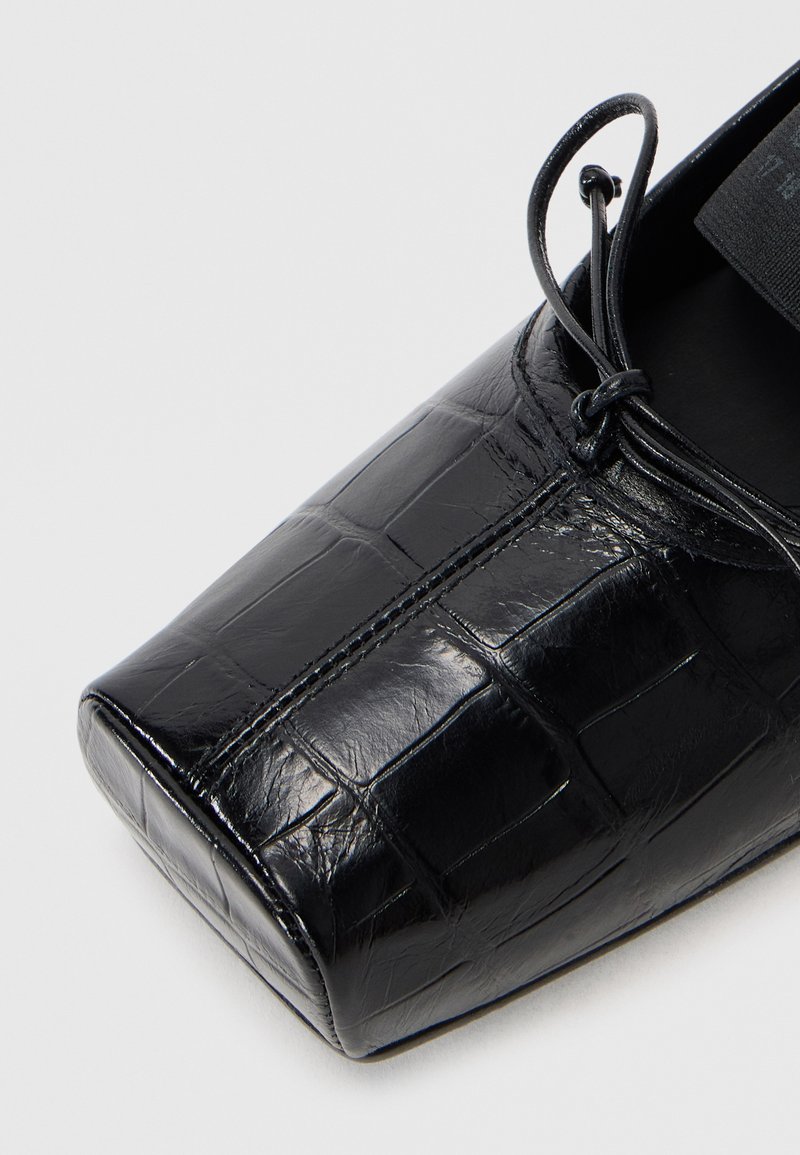Black, crocodile-embossed leather shoe with a square toe, lace detail, and a smooth texture. Features stitched accents along the shoe's upper.
