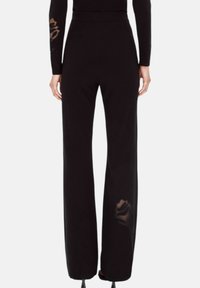 Zwarte wijde broek van een gestructureerde stof, met transparante accenten in rozenpatroon op de onderbenen en een hoog taille ontwerp.