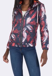 Lightweight navy jacket with red and white leaf pattern, zipper closure, and orange accents. Features elastic cuffs and hem for a fitted look.