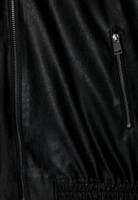 Czarna skórzana kurtka z zamkiem z przodu, teksturowaną powierzchnią i elastycznym pasem. Posiada boczną kieszeń z detalem w postaci zamka.