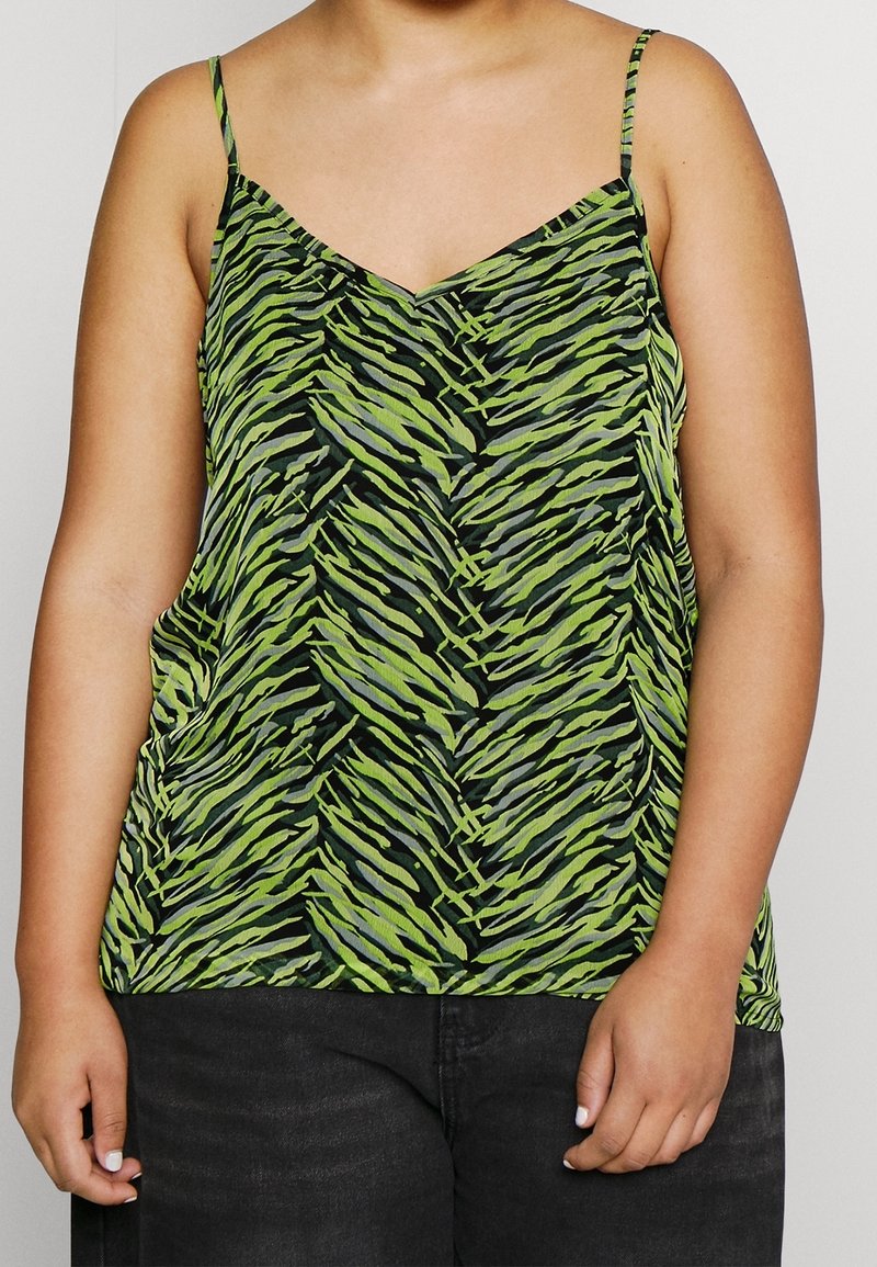 Camisole vert et noir à motifs avec des bretelles fines, présentant un motif en zigzag. Le tissu semble léger avec une texture lisse.