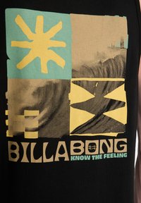 Μαύρο αμάνικο μπλουζάκι με πολύχρωμο γραφικό σχέδιο: κίτρινο σύμβολο ήλιου, μπεζ μοτίβα και κείμενο "BILLABONG" με ακουαρένια απόχρωση.