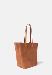 Tote-Bag aus hellbraunem Leder mit glatter Textur, hohem Design und zwei langen Griffen, die eine minimalistische Form ohne zusätzliche Beschläge aufweist.