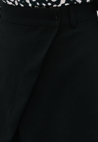 Zwarte stoffen rok met een knoopsluiting en een op maat gemaakte taille. Het materiaal lijkt glad met een lichte glans.