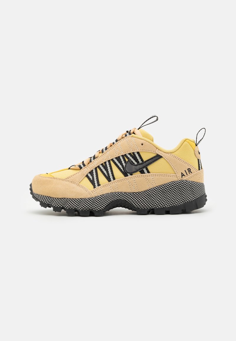 Gula och beige sneakers med svarta accenter, texturerat mockamaterial, zickzackmönster och slitstark sula, med draremmar på hälen.