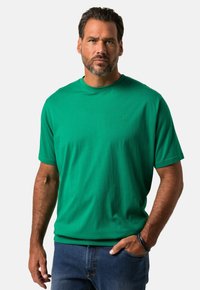 T-shirt verde a maniche corte realizzato in morbido tessuto, con scollatura rotonda e un logo discreto sul petto. Nota per il suo colore vivace.