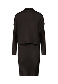 Robe en maille côtelée noire avec manches longues et un top superposé ample à col montant couvrant le haut du torse.