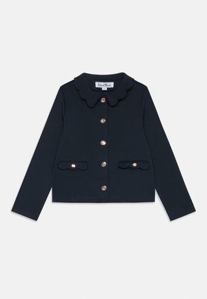 Marineblaues kurz geschnittenes Cardigan mit gewelltem Kragen, sechs goldenen Knöpfen und zwei gewellten Fronttaschen. Glatte Stofftextur.