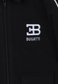 Giacca nera con zip e colletto, con logo Bugatti ricamato in bianco. Realizzata in tessuto liscio con dettagli sulla tasca frontale.
