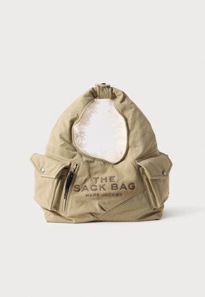 Sac en tissu beige Marc Jacobs avec deux poches à rabat, une poche zippée et le texte "THE SACK BAG" à l’avant.