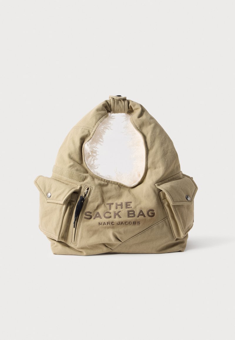 Sac en tissu beige Marc Jacobs avec deux poches à rabat, une poche zippée et le texte "THE SACK BAG" à l’avant.