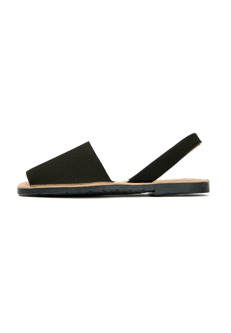 Black suede sandal with a wide, asymmetrical upper and a back strap. Features a natural-colored sole with a textured, durable bottom.