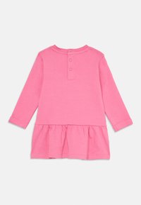 Robe à manches longues en coton rose vif, avec un col rond, une patte de boutonnage dans le dos et un bas de robe évasé et froncé.