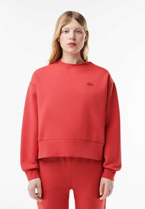 Rode sweatshirt met een ronde hals, lange mouwen en geribde boorden. Bevat een textuur logo op de borst en heeft een relaxte pasvorm.