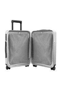 Spinner suitcase with a silver hard shell, grid-patterned interior, dual compartments, retractable handle, and four black wheels for easy mobility.