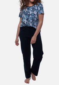 Top a maniche corte floreale nelle tonalità di blu e bianco, abbinato a pantaloni con coulisse navy, caratterizzati da una vestibilità comoda e un tessuto morbido.