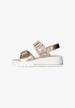 Sandalo metallico color oro rosa con due cinturini regolabili con fibbia e suola platform bianca visto di lato su sfondo bianco.