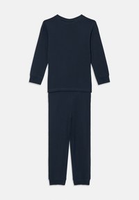 Marineblauwe katoenen pyjama set bestaande uit een langemouwen top met een ronde halslijn en bijpassende broek met elastische tailleband en omslagoevers.