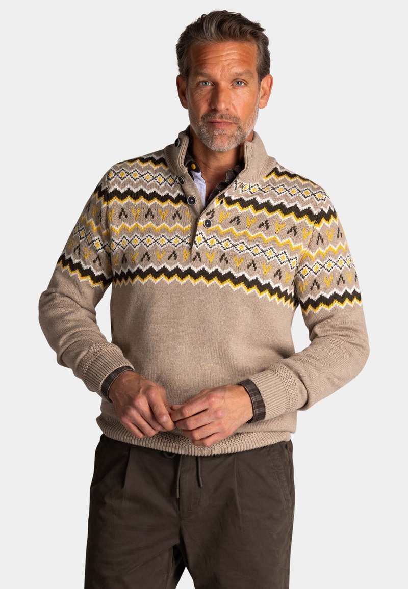 Beige pullover trui met een gestreepte schouderpartij met zigzagpatronen in geel, bruin en wit. Halflange knoopsluiting bij de kraag en boordjes aan de mouwen.