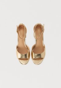 Gouden metallic hoge hakken sandalen met een open teen en enkelband, met een gladde textuur en een minimalistisch ontwerp.