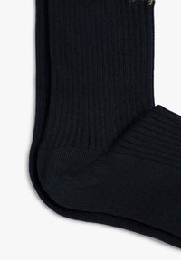 Calcetines acanalados de color azul marino oscuro, fabricados en un tejido suave, con refuerzos en las zonas del talón y los dedos, y una textura suave en todo su interior.