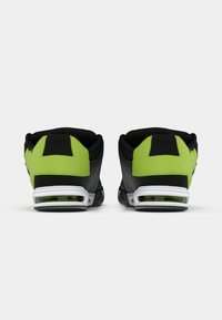 Schwarze und limegrüne Sportschuhe mit einem gepolsterten Kragen, strukturiertem Material und weißer Zwischensohle. Verfügt über eine sichtbare Luftdämpfungseinheit.